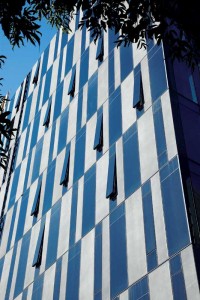 The west side of the building showing matte, dark grey ultra-high-performance concrete (UHPC) panels with tinted glazing. Photo © Patrick Kennedy