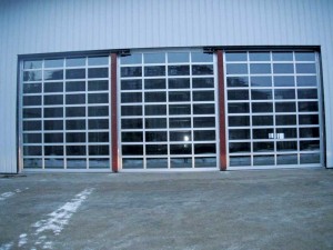 This is a series of three sectional aluminum overhead doors separated by a moveable vertical mullion that, when fully open, gives the maximum width clearance available. It is used where overhead doors are required by one door width that needs to be maximized.