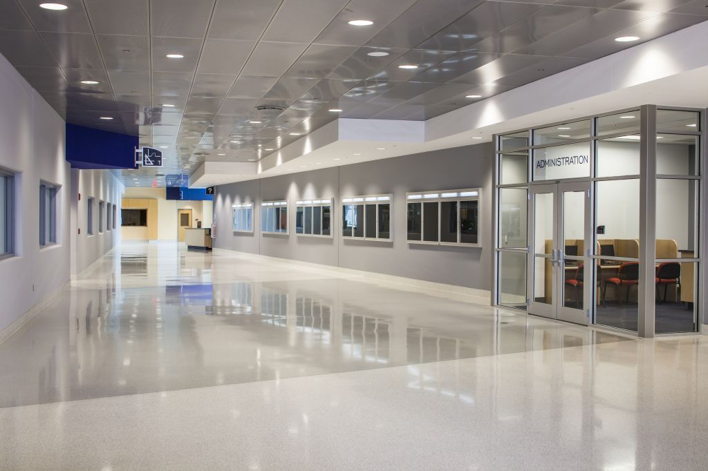 In large multi-purpose spaces with expansive hard surfaces, perforating the metal ceiling panels and adding an acoustic backer can help manage the reverberation and improve sound quality.