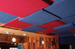 Ceiling-mounted panels of varying depths provide broad-spectrum sound absorption and diffusion.