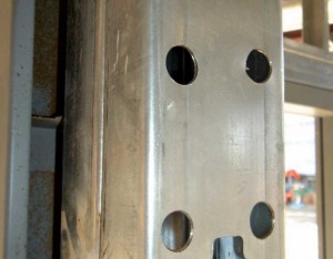 Pre-assembled built-up jamb studs are difficult to connect to a pre-assembled hollow metal frame (HMF). One workaround is to cut holes through one side of the stud to screw through the interior of the opposite side into the HMF. This can be difficult to inspect and may cause delays.