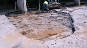 The photo above shows the beginning of a concrete topping slab removal in order to replace a failed peel-and-stick waterproofing membrane. Deck construction did not incorporate a drainage layer at the membrane level, which led to premature failure.