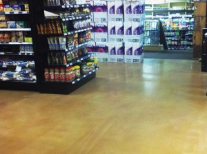 The floor of this supermarket in Whistler, B.C., is a fast-curing cementitious overlay. The as-poured surface was not ground or otherwise mechanically or chemically profiled. It was dyed, densified, and burnished. It was treated with silica-polymer dispersion stain protector and burnished again to a reflective shine.