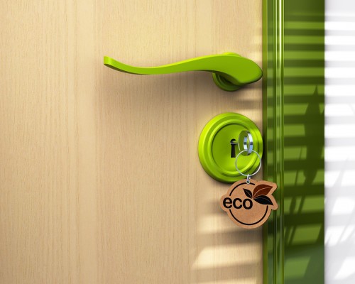 Close up of a door and a key ring where it's written the word eco the lock is green there is a copy space on bottom left