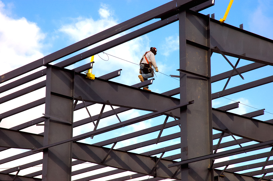 Structural steel worker walking on girders roof