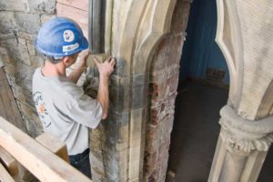 The natural stone façade of the Parliament Buildings effectively demonstrated architectural distinction by incorporating texture and a strong sense of definition, accomplished in part by careful stone selection and expert placement around windows, doors, and entranceways. In this photograph, a masonry worker ensures proper placement and fitting of a masonry unit cleaned using innovative laser technology. Photo courtesy Public Works Canada.