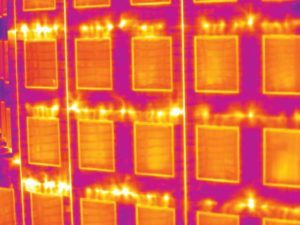 Prefabricated wall panels can expedite construction. However, tie-ins between panels must still be carefully treated to prevent systemic issues such as air leakage, shown in this thermographic scan. This close-up shows air leakage at panel joints.