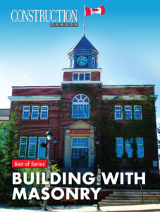 Two-storey brick building with clock tower, blue sky.