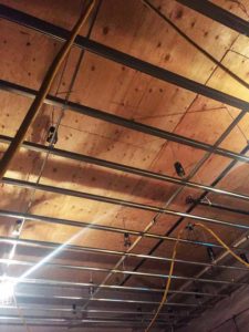 Installation of resiliently hung gypsum ceilings. Photo courtesy Lynx Music