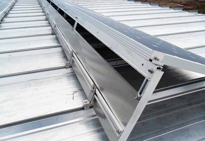 A standing-seam roof where racking has been clipped over the ridges, resulting in a fixed system with no roof penetrations.