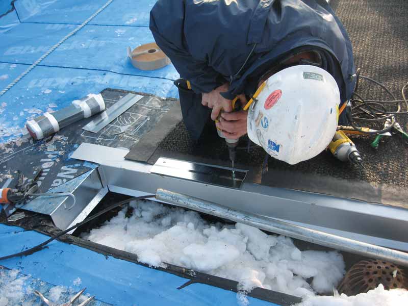 A contractor working at critical details during winter conditions.