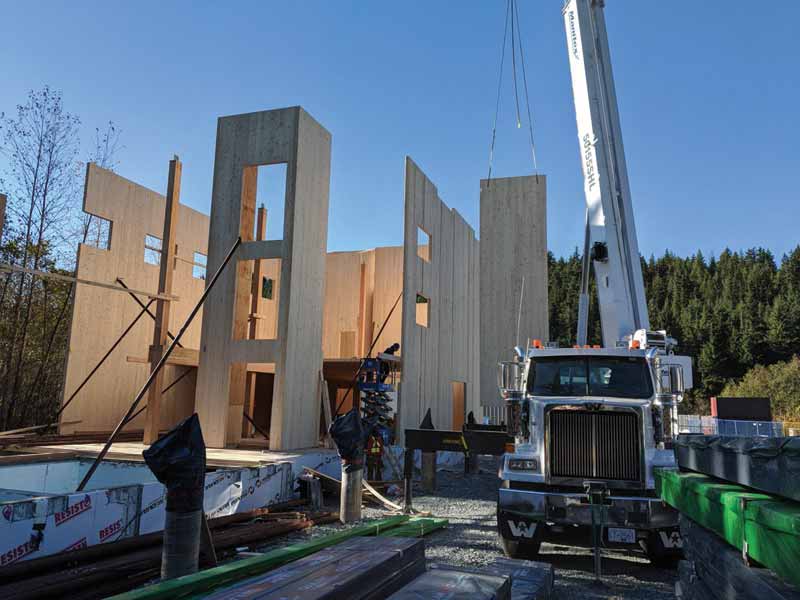 The cross-laminated timber (CLT) wall panels of the Whistler Community Services Society (WCSS) building in B.C., together with the elevator and stair cores, run from grade beam to eaves, as in balloon frame construction. The panels were lifted off the truck and lowered directly into place. Photo courtesy Fast + Epp