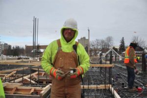 A construction worker on a jobsite displaying a concrete wireless sensor pre-installation.