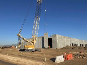 A concrete wall being hoisted into place.