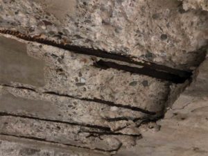 Structural deterioration as a result of a failure of the podium deck waterproofing system.