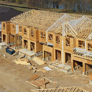 A row of houses under construction, with their wooden structures built out. 