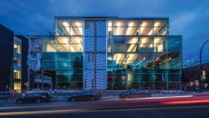 West elevation of completed building at night.