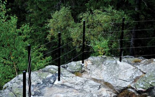 A cable railing encloses a rocky boundary.