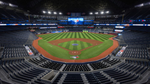 An empty Rogers Centre poised for play, showcasing its expansive seating and state-of-the-art field under dramatic lighting.