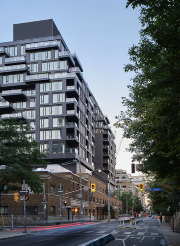 mid-rise condo building with glass windows on an isolated street