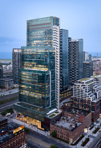 high rise building with glass exterior and cityscape backdrop