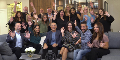 group of happy, smiling people with arms stretched out.