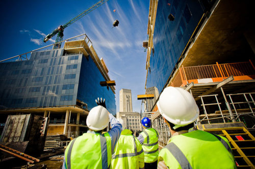 construction workers looking at a building construction and discussing something