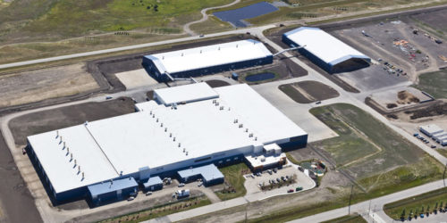 aerial view of industrial stretch of land with a large facility in the middle