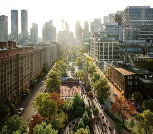 aerial view of a cityscape with a green strip running through the middle of the street with trees