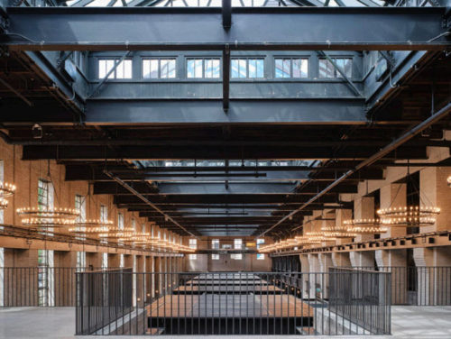 interior of a historic building with a pitched roof and oversized skylights on both sides