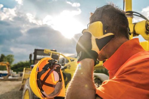 construction worker covering his ears with headphones